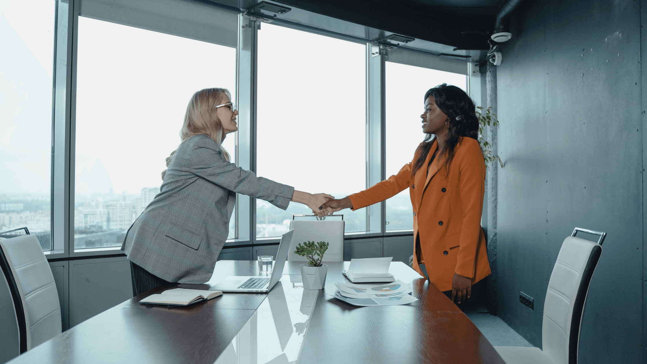 Two women shaking hands after a negotiation 